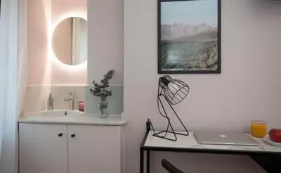 a bathroom with a sink and a desk with a laptop at Palacios Rooms in Valencia