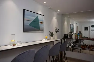 a bar with chairs and a counter with a picture on the wall at Palacios Rooms in Valencia