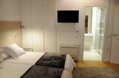 a bedroom with a bed and a tv on the wall at Mon Suites San Martin in Valencia