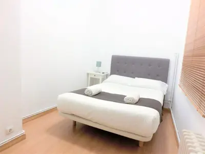 a bedroom with a bed with white sheets and pillows at Total Valencia Mercat in Valencia