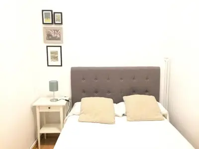 a bedroom with a white bed with a black headboard at Total Valencia Mercat in Valencia