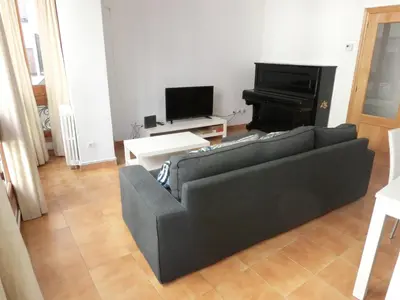a living room with a black couch and a piano at Total Valencia Mercat in Valencia