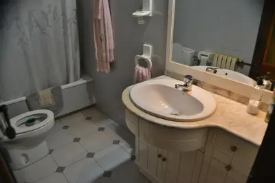 a bathroom with a sink and a toilet and a mirror at Casa Las Violetas in Altura