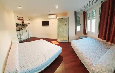 a bedroom with two beds and a walk in shower at Habitación cerca del centro in Valencia