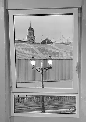 a window with a view of a building with a street light at Habitación cerca del centro in Valencia