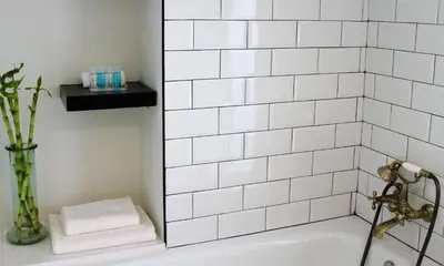 a white tiled bathroom with a bath tub with a sink at Apartamento Con Vistas Espectaculares in Valencia