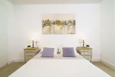 a bedroom with a white bed with purple pillows at Vivaldi Center City in Valencia