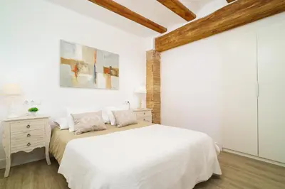 a white bedroom with a bed and a wooden ceiling at Vivaldi Center City in Valencia