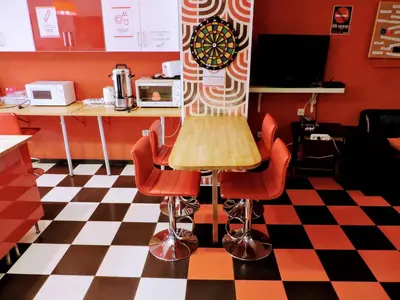 a kitchen with a table and chairs on a checkered floor at Feetup Home Backpackers Valencia in Valencia