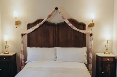 a bedroom with a canopy bed with white pillows at Hotel Restaurante Doña Anita in Requena