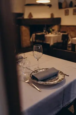 a table with a plate and wine glasses on it at Hotel Restaurante Doña Anita in Requena