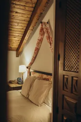 a bedroom with a bed with a wooden ceiling at Hotel Restaurante Doña Anita in Requena