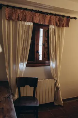 a room with a window and a chair and a window istg at Hotel Restaurante Doña Anita in Requena