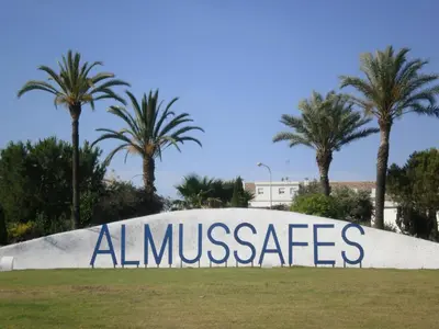 a sign that says almusacs in a park with palm trees at Hotel Isabel in Almussafes