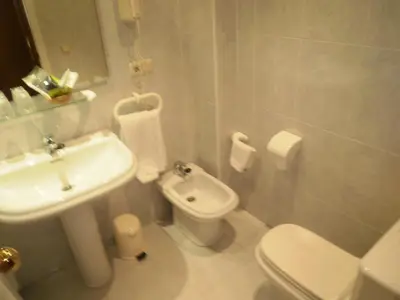 a white bathroom with a sink and a toilet at Hotel Isabel in Almussafes