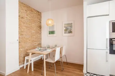 a dining room with a wooden table and white chairs at Casa Marcellino Valencia Centro in Valencia