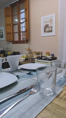 a wooden table with plates and utensils on it at Hostal El Convent de Moncada in Moncada