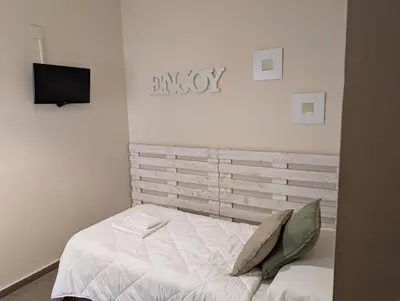 a bedroom with a bed and a tv on the wall at Hostal El Convent de Moncada in Moncada
