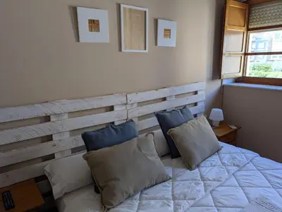 a bedroom with a wooden headboard and a bed with pillows at Hostal El Convent de Moncada in Moncada