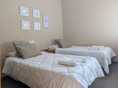 a bedroom with two beds with towels on them at Hostal El Convent de Moncada in Moncada