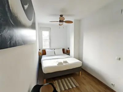 a bedroom with a bed and a ceiling fan at Hola Valencia - Holiday Apartments in Valencia