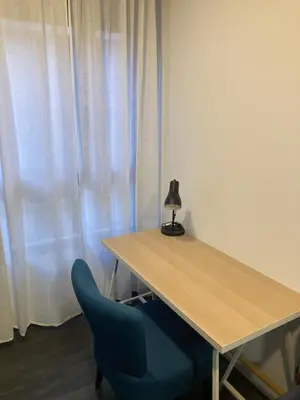a wooden table with a blue chair and a lamp at Apartment Sofi in Valencia