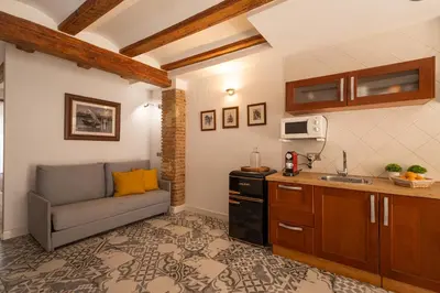 a living room with a couch and a kitchen at FLORIT FLATS - Charming Ruzafa Apartment & Terrace in Valencia