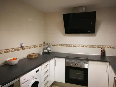 a kitchen with white cabinets and a sink and a window at Calle Mora De Rubielos in Valencia