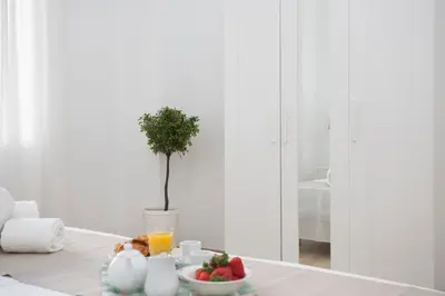 a table with a bowl of fruit and a vase with a tree at Antiguo Reino Apartment in Valencia
