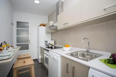 a kitchen with white cabinets and a sink at Antiguo Reino Apartment in Valencia