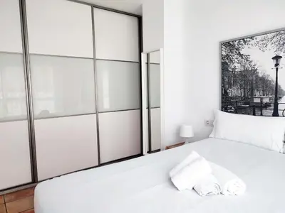a white bed in a room with windows at Flats Friends Nave in Valencia