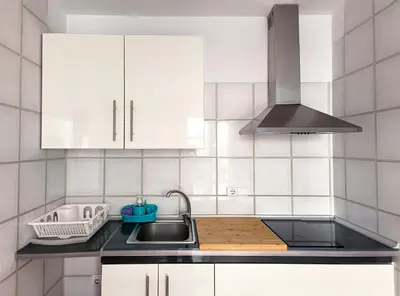a kitchen with white cabinets and a sink at Flats Friends Nave in Valencia