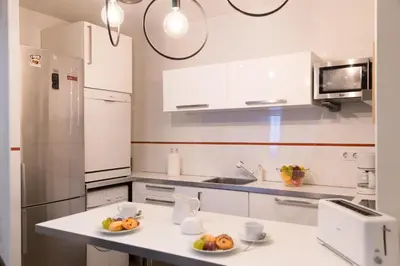 a kitchen with white cabinets and fruit on a counter at MD Oliag in Valencia