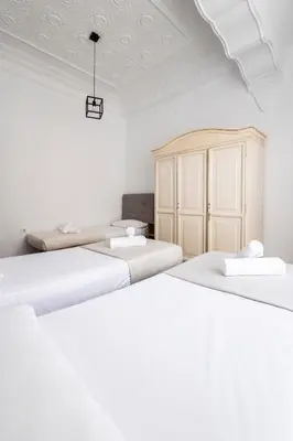 a white room with three beds and a cabinet at Live in Chianti Apartaments by Concept Flats in Valencia