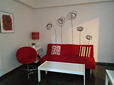 a living room with a red couch and a red chair at Apartamento valencia centro in Valencia