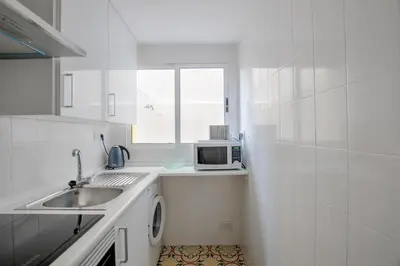 a white kitchen with a sink and a microwave at Apartamento valencia centro in Valencia