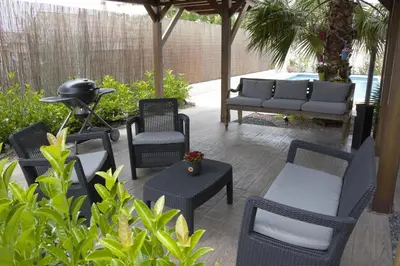 a patio with chairs and tables and a couch at Hotel Vista al Sol in Paterna