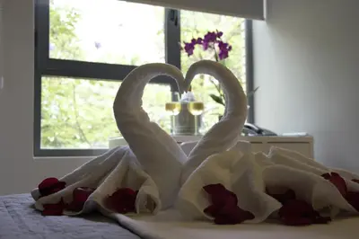 two white swans forming a heart on a bed at Hotel Vista al Sol in Paterna