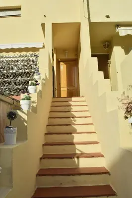 a staircase leading up to a house with potted plants at Dúplex, piscina y playa in Puebla de Farnals