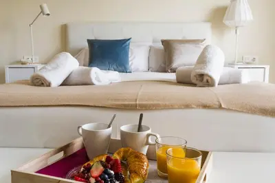 a tray of fruit on a table in front of a bed at HQ Rooms Apartments San Vicente in Valencia