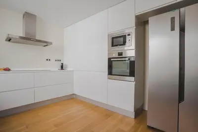 a kitchen with white cabinets and stainless steel appliances at HQ Rooms Apartments San Vicente in Valencia