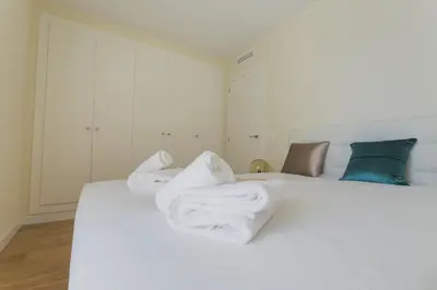 a bedroom with a white bed with towels on it at HQ Rooms Apartments San Vicente in Valencia