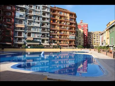 a large swimming pool in front of a building at Cozy apartment on the sea in Port Saplaya