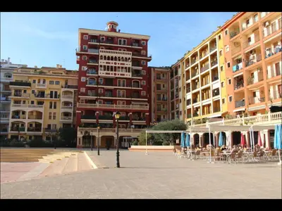 a group of buildings with tables and chairs in a courtyard at Cozy apartment on the sea in Port Saplaya