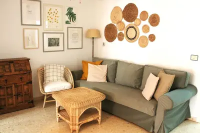 a living room with a green couch and a chair at Cozy apartment on the sea in Port Saplaya