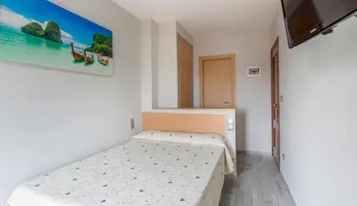 a bedroom with a bed and a painting on the wall at Olympia Ronda Hostel in El Puig