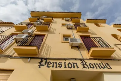 a building with windows and a sign for a fashion boutique at Olympia Ronda Hostel in El Puig