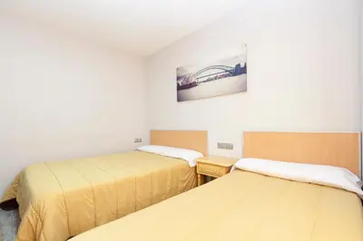 a room with two beds and a picture on the wall at Olympia Ronda Hostel in El Puig