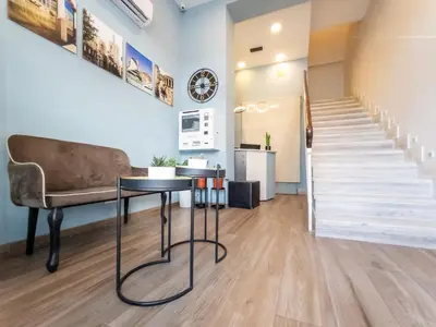 a living room with a table and a chair and stairs at Dormavalencia Hostel Regne in Valencia