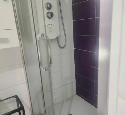 a shower with a glass door in a bathroom at Avenue Rooms in Valencia